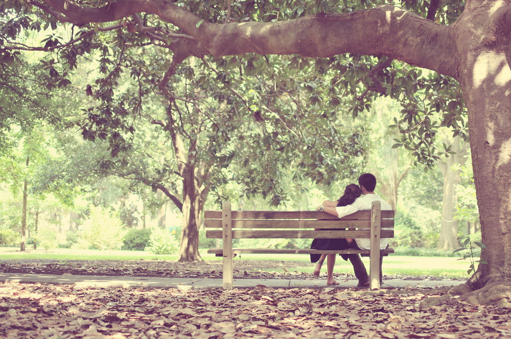 girlfriend boyfriend sitting on outdoor bench