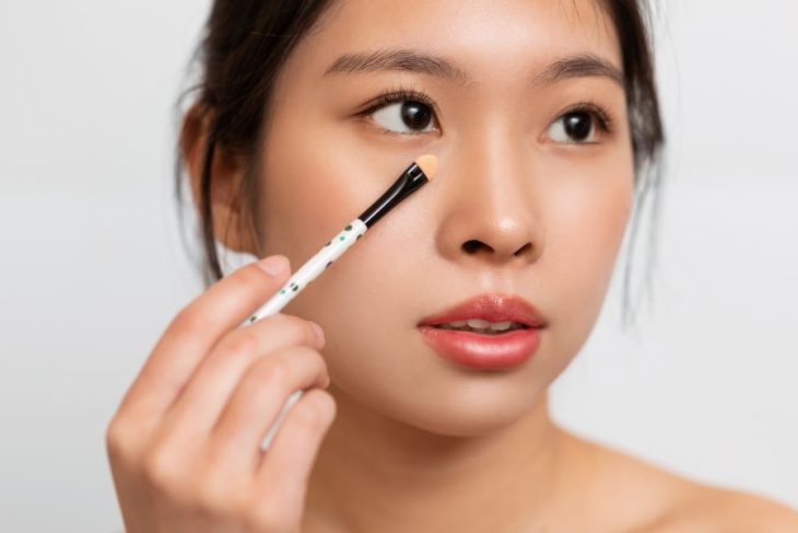 woman applying concealer