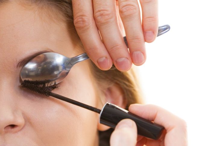 woman applying mascara with spoon