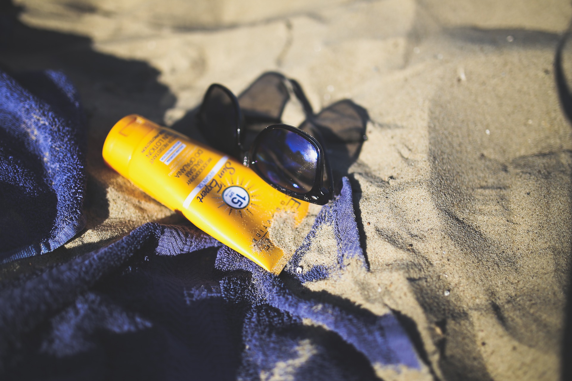 Sunscreen and sunglasses by the beach