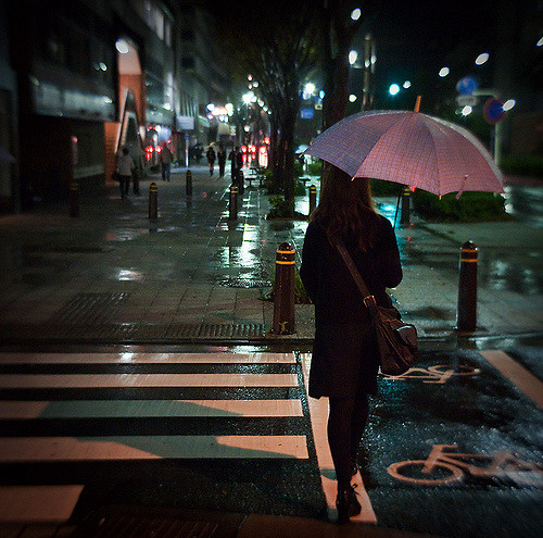 Woman About to Cross the Road While Holding an Umbrella in the Rain