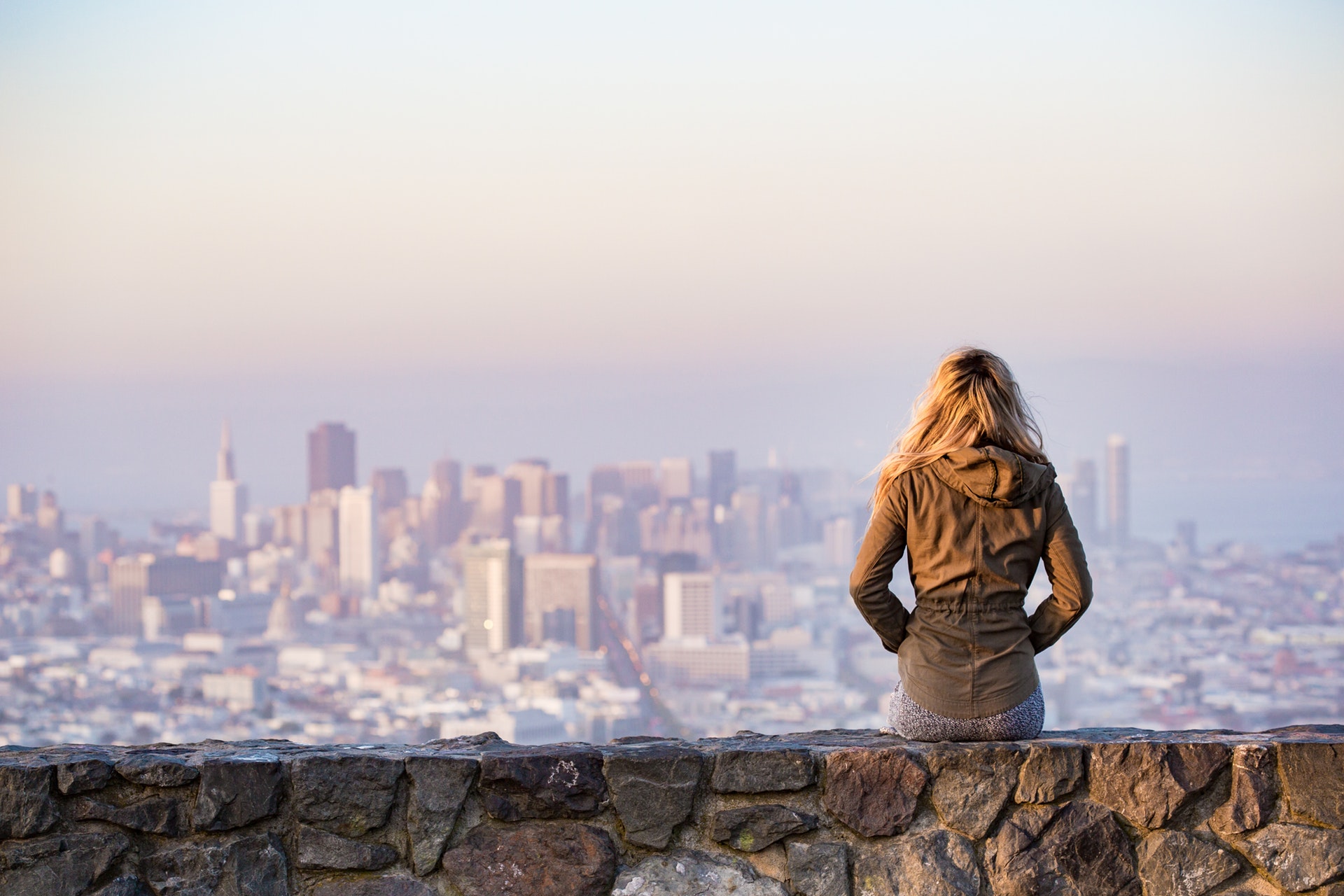 Woman Sitting On A Rock Wall