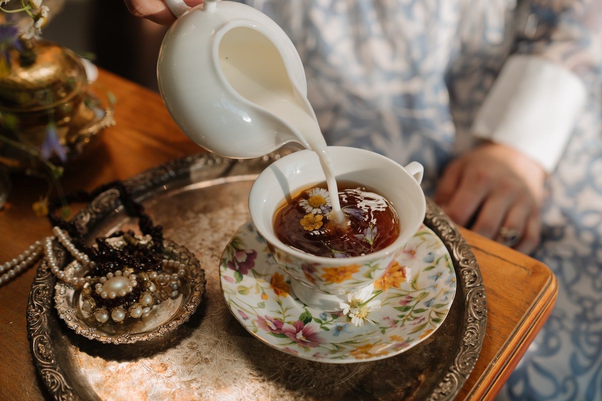 pouring milk on chamomile tea