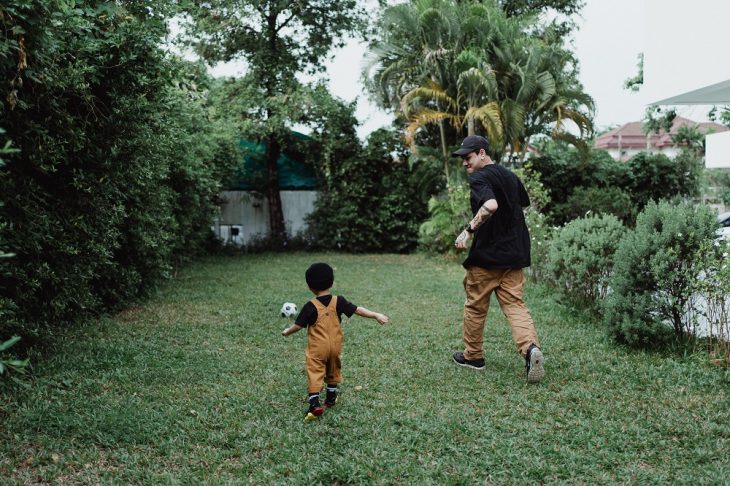 Father and Son Playing Football in the Backyard 