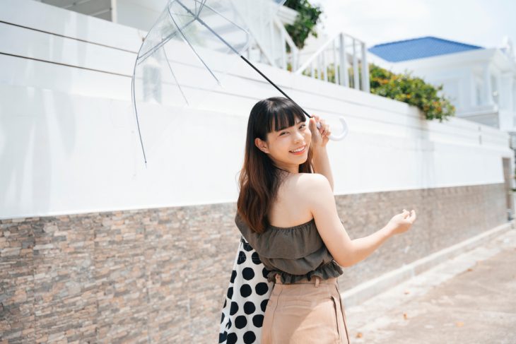 happy asian woman under the sun with umbrella