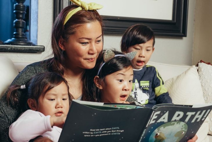 mother reading a book to kids