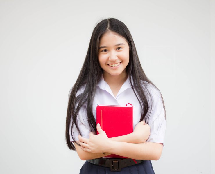 a filipina student carrying a red notebook
