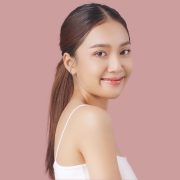 a young woman smiling against a pink backdrop