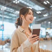 a woman in an airport holding a passport