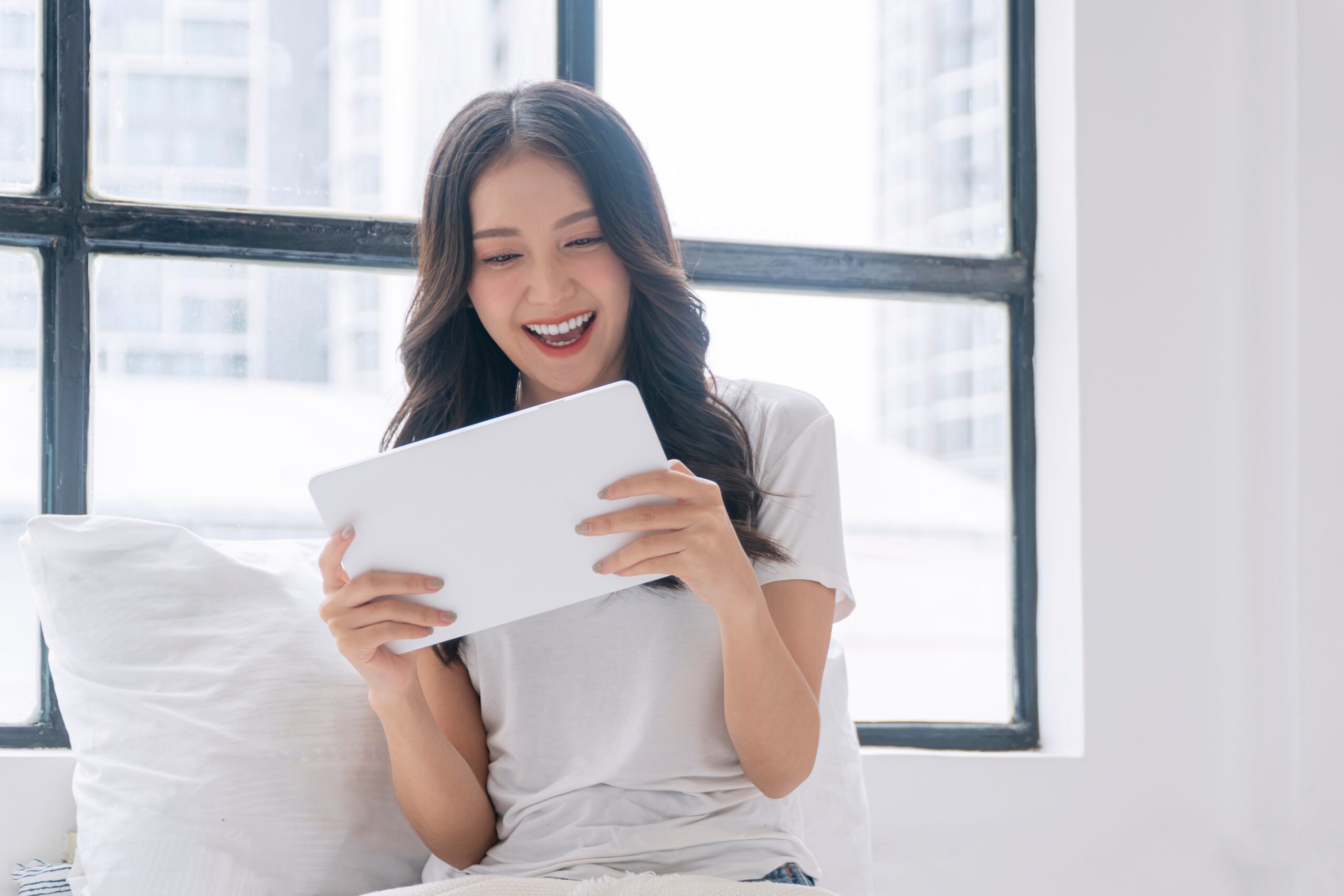a young woman playing on her tablet