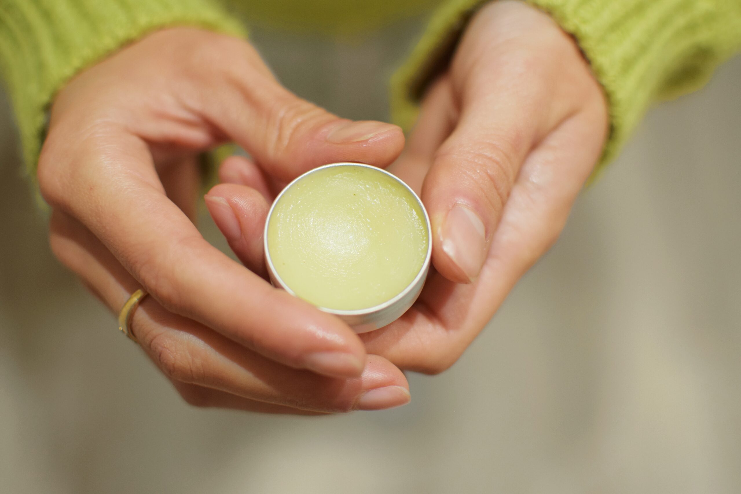 a woman holding a lipbalm