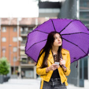 a young lady holding a purple umbrella