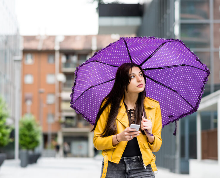 a young lady holding a purple umbrella