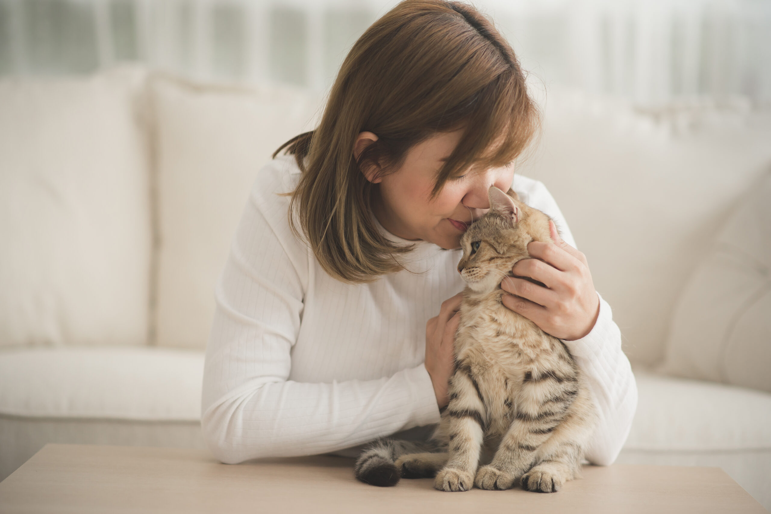 a young woman kissing her cat
