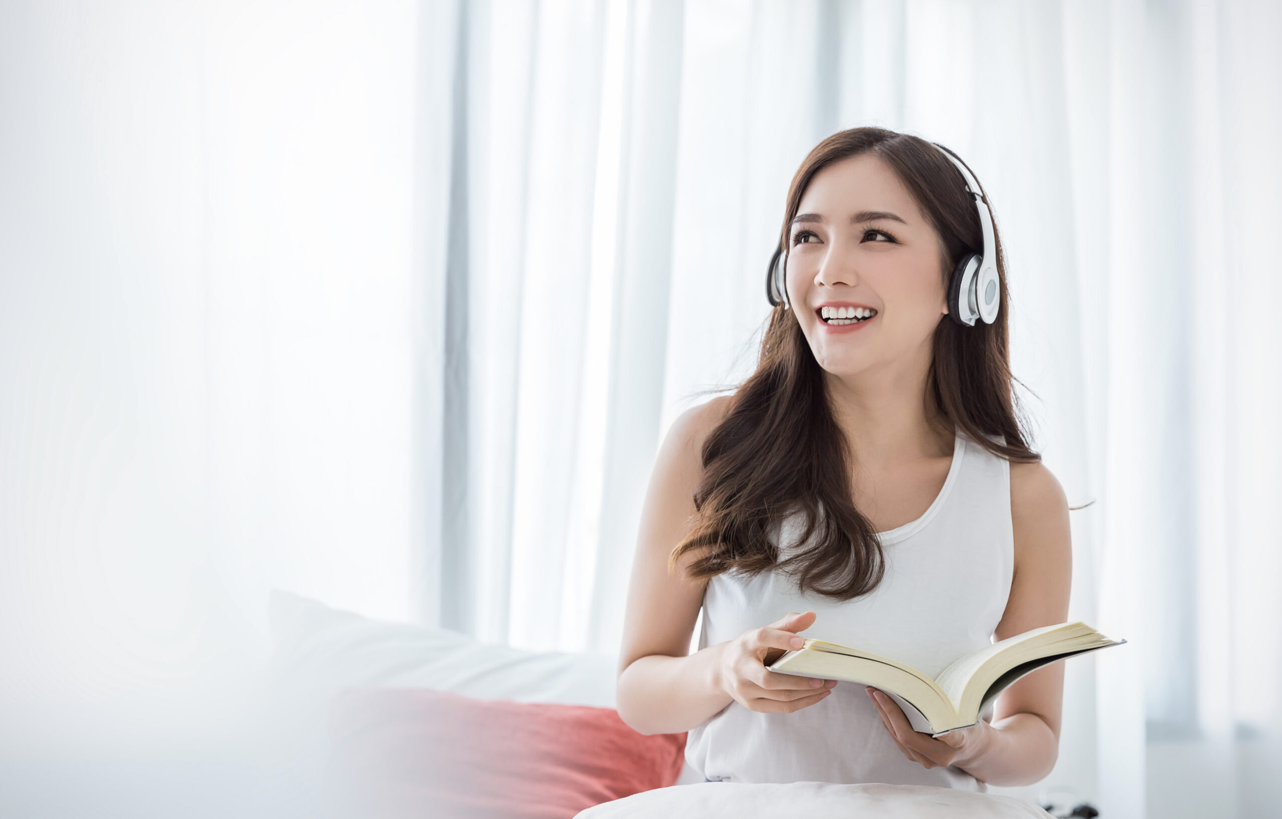 a woman listening to a podcast while holding a book