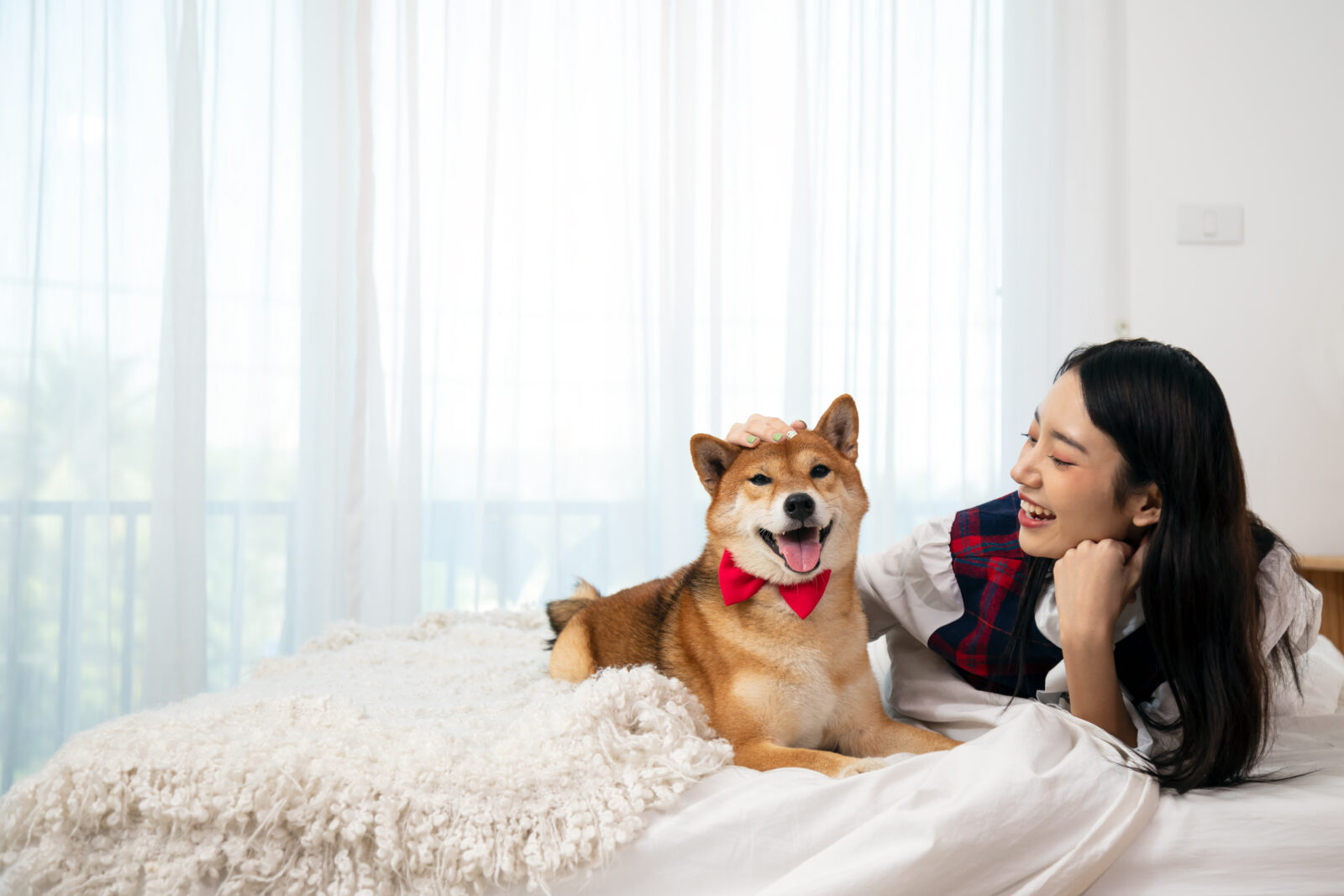 a lady and her dog on the bed smiling