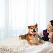a lady and her dog on the bed smiling