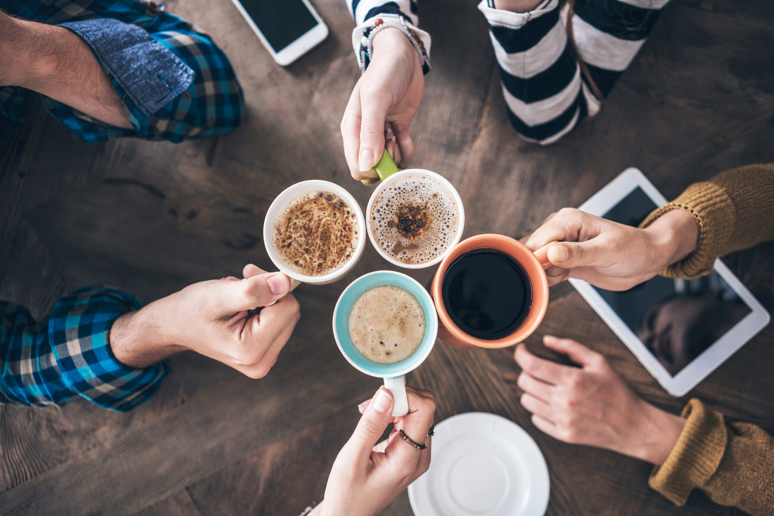 group of friends holding ceramic mugs
