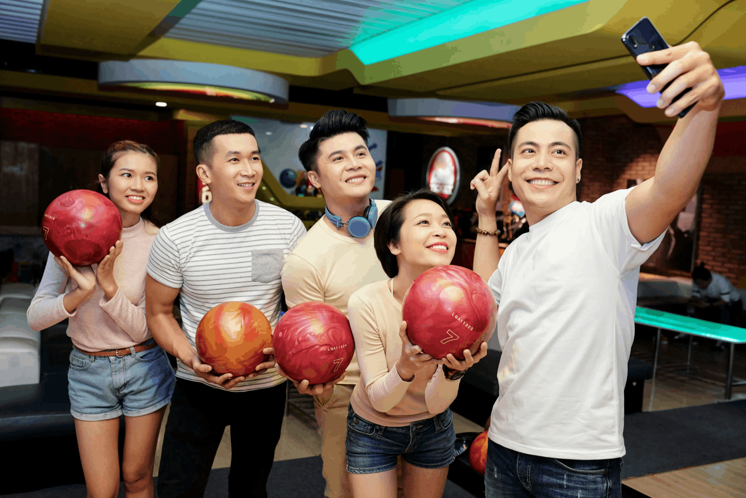 group of friends posing for a bowling photo