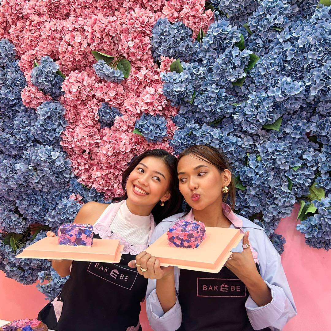 two female friends holding cakes