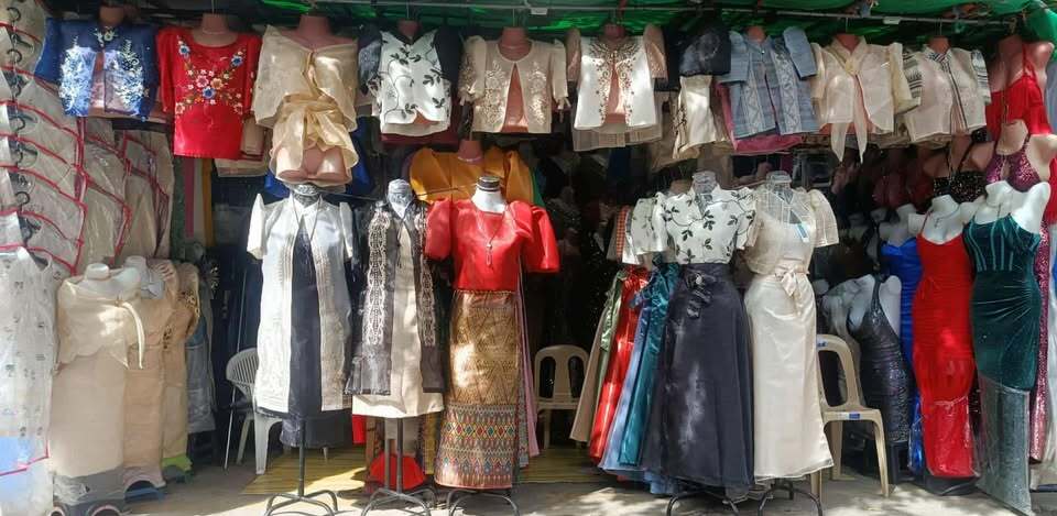 A storefront display featuring traditional Filipino garments, including Barongs and Filipiniana dresses.