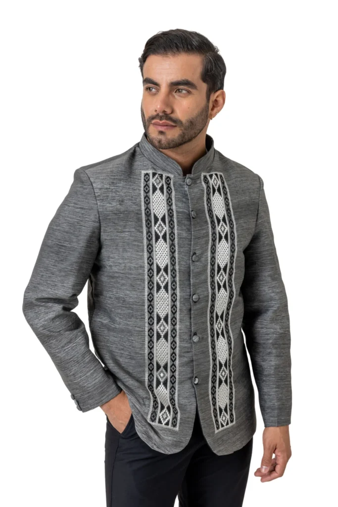 A man wearing dark grey barong with black and white geometric embroidery on front.