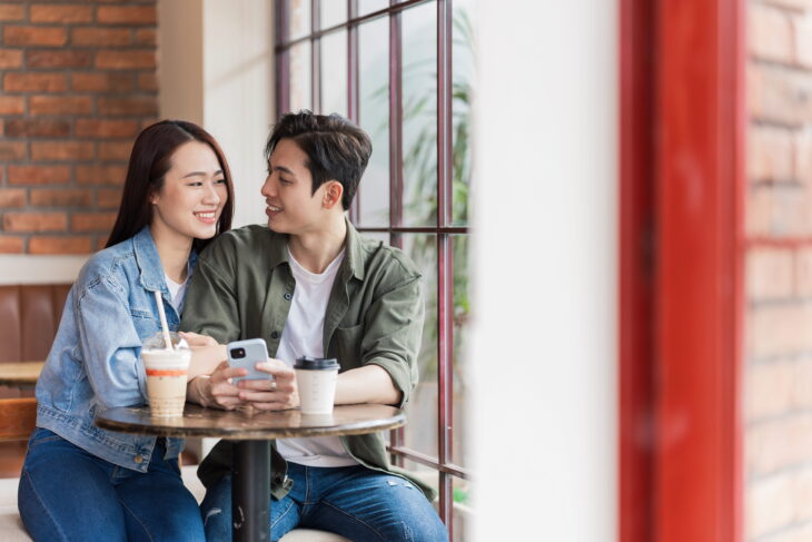 Young couple smiling together while having coffee